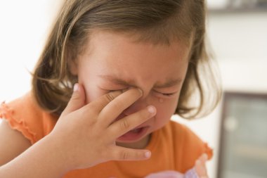 Young girl indoors crying clipart