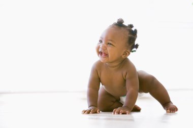 Baby crawling indoors smiling clipart