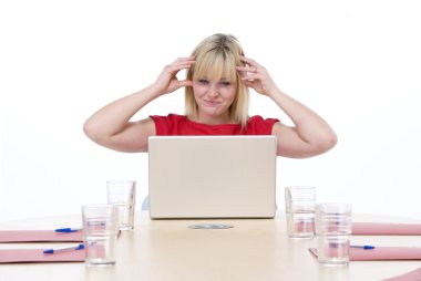 Businesswoman sitting in boardroom with laptop looking frustrate clipart