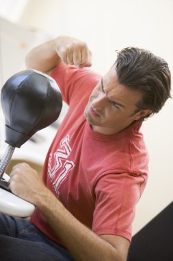 Man indoors using small punching bag clipart