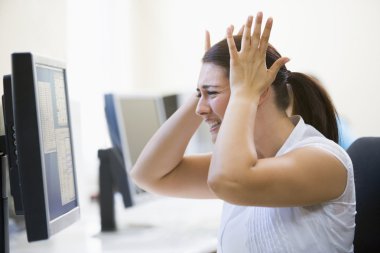 Woman in computer room looking frustrated clipart