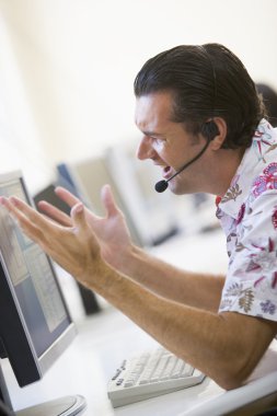 Man in computer room wearing headset looking frustrated clipart