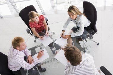 Four businesspeople in a boardroom with paperwork clipart