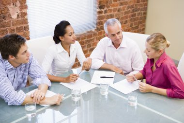 Four businesspeople in boardroom talking clipart