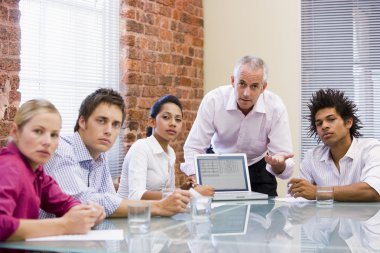 Five businesspeople in boardroom with laptop clipart