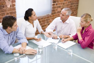 Four businesspeople in boardroom meeting clipart