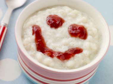 Bowl of Creamed Rice Pudding with a Strawberry Jam Face clipart