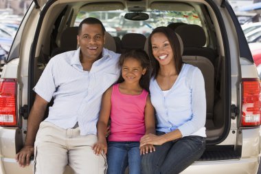 Family sitting in back of van smiling clipart