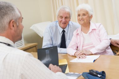 Couple in doctor's office smiling clipart