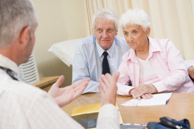 Couple in doctor's office frowning clipart