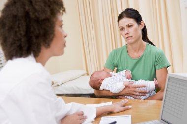 Doctor with laptop and woman in doctor's office holding baby clipart