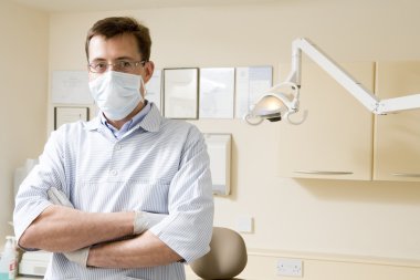 Dentist in exam room with mask on clipart