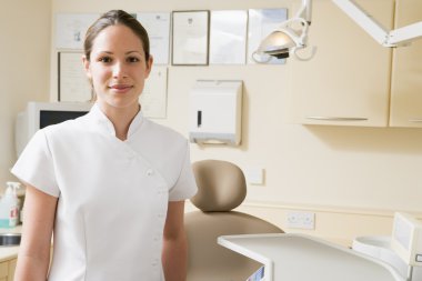 Dental assistant in exam room smiling clipart