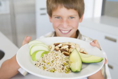 Boy holding up a plate of healthy food items clipart