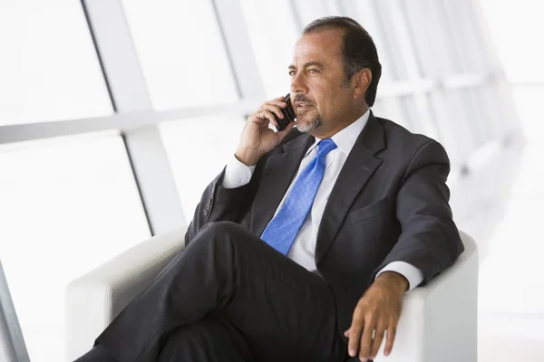 stock image Businessman talking on mobile phone in office lobby