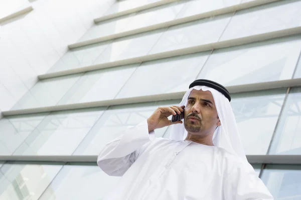 Μια Μεσο-Ανατολική επιχειρηματίας, μιλώντας στο τηλέφωνο έξω από μια off — Φωτογραφία Αρχείου