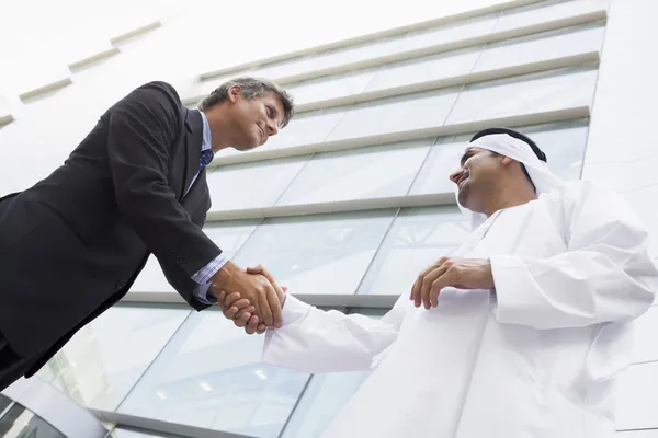 Um empresário do Oriente Médio e um homem caucasiano a apertar as mãos — Fotografia de Stock
