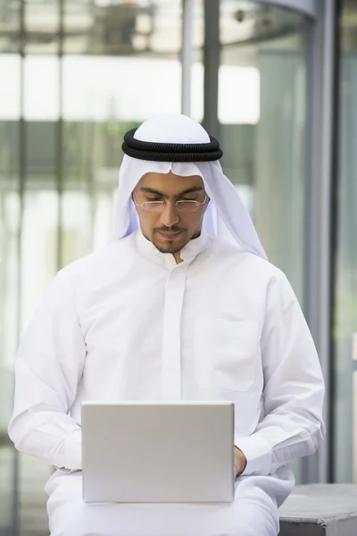 用一台笔记本电脑坐在一个中东商人 — 图库照片