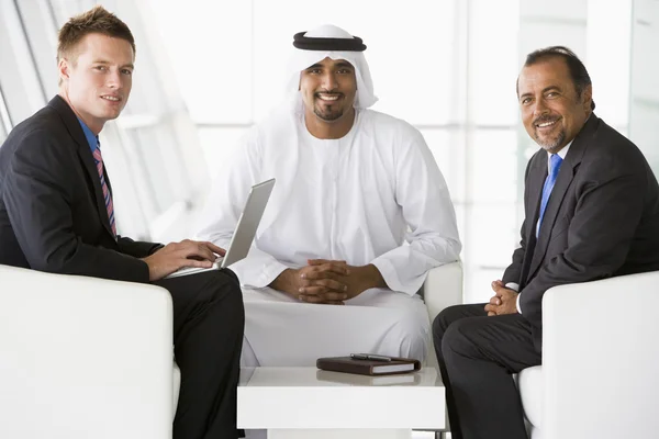 Due uomini mediorientali e un uomo caucasico che parlano in un'azienda — Foto Stock