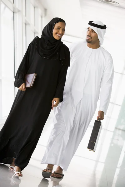 Um empresário do Oriente Médio e uma mulher caminhando em um corredor — Fotografia de Stock