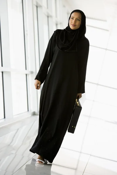 Una donna d'affari mediorientale che cammina in un corridoio — Foto Stock