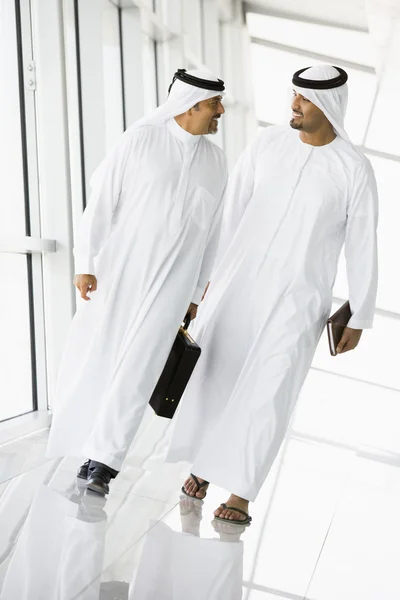 Dois empresários do Oriente Médio caminhando em um corredor — Fotografia de Stock