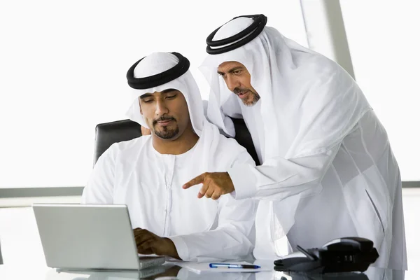 在一台笔记本电脑旁边的两个中东商人 — 图库照片