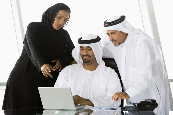 两个中东商人及一名女子在一台笔记本电脑旁边 — 图库照片