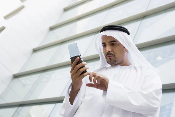 Um empresário do Oriente Médio usando um PDA — Fotografia de Stock