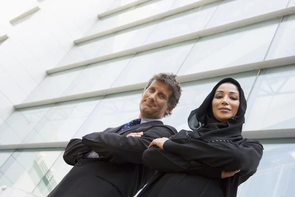 Ближневосточная деловая женщина и кавказский бизнесмен улыбаются — стоковое фото