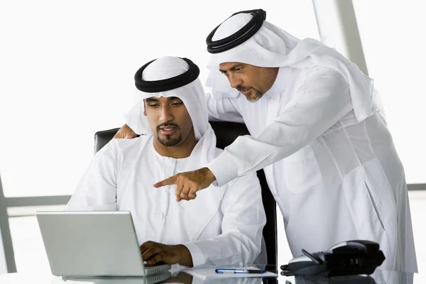 Zwei Geschäftsleute aus dem Mittleren Osten schauen auf einen Computer — Stockfoto