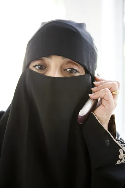 Uma mulher do Médio Oriente falando em um celular — Fotografia de Stock
