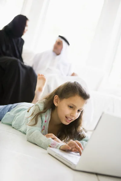 Девушка с Ближнего Востока лежит на полу с ноутбуком — стоковое фото