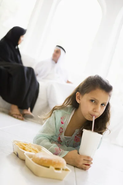 Una ragazza mediorientale che si gode un pasto di hamburger fast food — Foto Stock