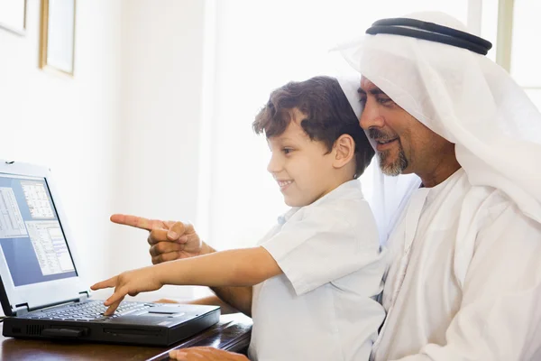 중동 남자와 그의 아들은 컴퓨터 앞에 앉아 — 스톡 사진