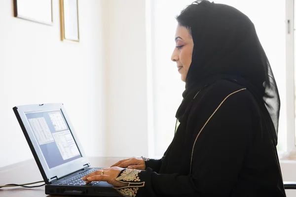 坐在家里的电脑前 一个中东女人 — 图库照片