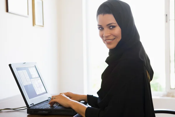 坐在家里的电脑前 一个中东女人 — 图库照片
