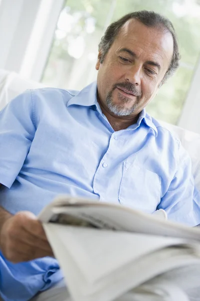 A Middle Eastern man reading a newspaper at home — Stock Photo, Image