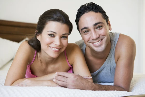 A Middle Eastern couple lying on a bed — Stock Photo, Image