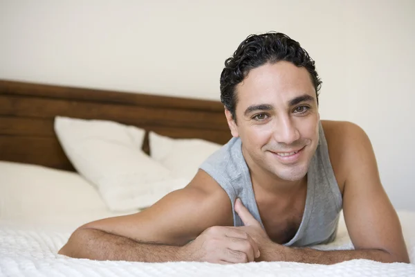 Um homem do Oriente Médio deitado em uma cama — Fotografia de Stock