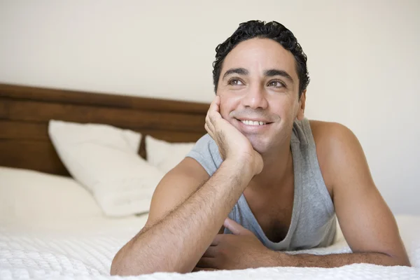 A Middle Eastern man lying on a bed — Stock Photo, Image