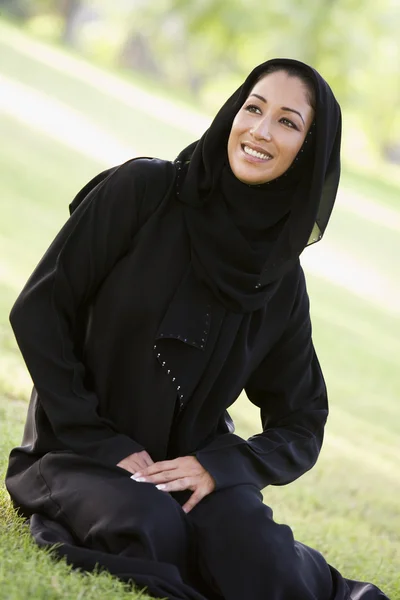 Una donna mediorientale seduta in un parco — Foto Stock