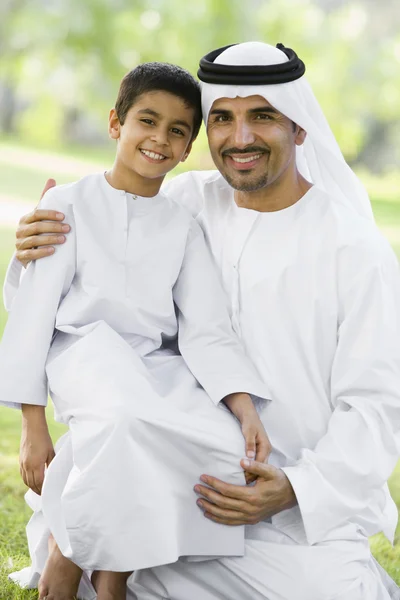 Ένας άνθρωπος της Μέσης Ανατολής και ο γιος του κάθεται σε ένα πάρκο — Φωτογραφία Αρχείου
