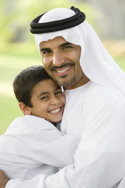 中東の男と彼の息子の公園で座っています — ストック写真