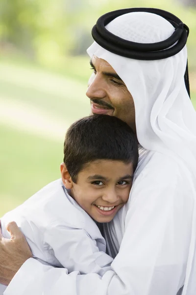 Un homme du Moyen-Orient et son fils assis dans un parc — Photo