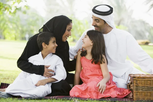 En Mellanöstern familj som sitter i en park — Stockfoto