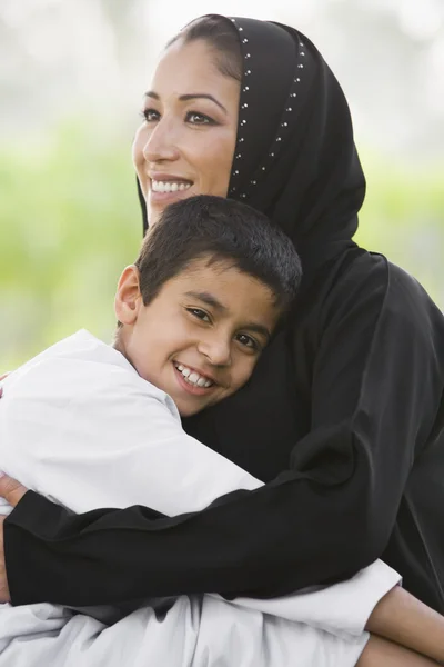 Женщина с Ближнего Востока и ее сын сидят в парке — стоковое фото