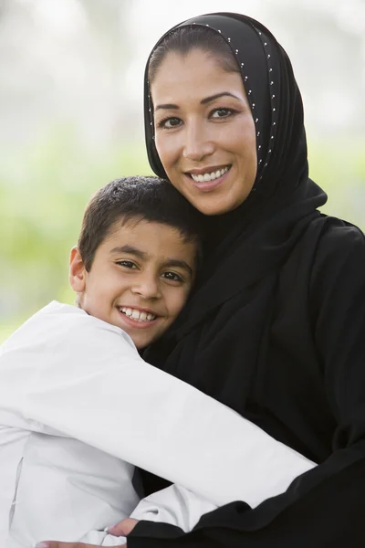 一个中东的女人和她的儿子坐在一个公园 — 图库照片