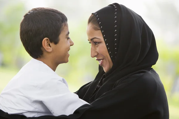 一个中东的女人和她的儿子坐在一个公园 — 图库照片