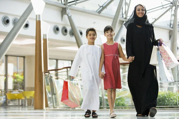A Middle Eastern woman with two children in a shopping mall — Stock Photo, Image